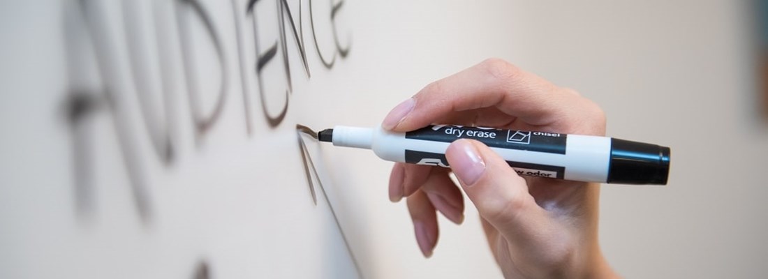 The word 'audience' written on a white board.