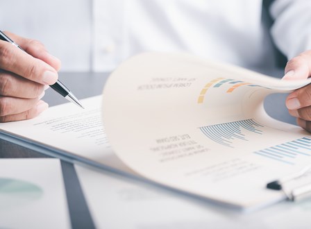 Group of people sat in a room watching a man present stood up