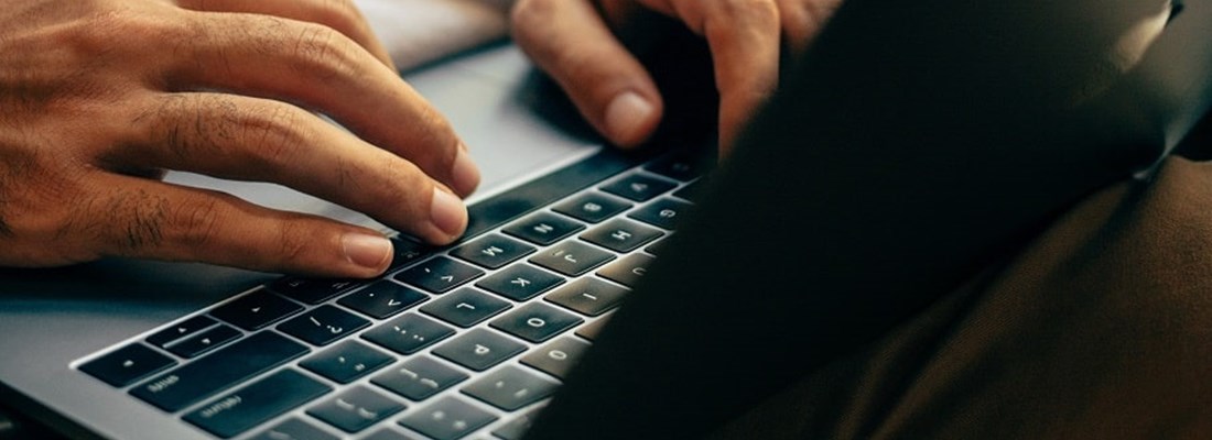 Hands writing on a laptop