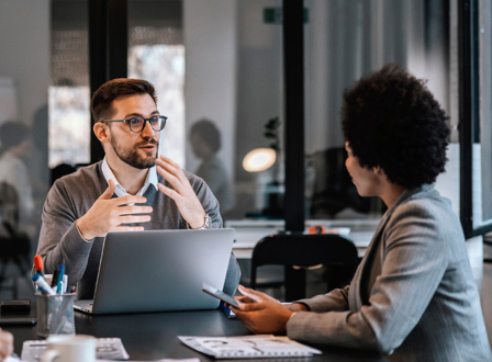 Group of people sat in a room watching a man present stood up