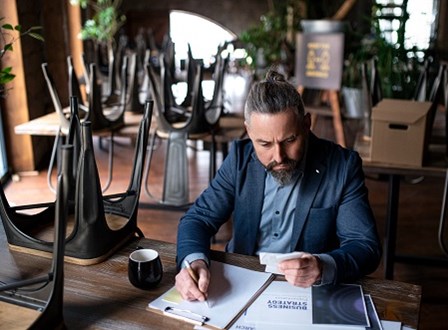 Group of people sat in a room watching a man present stood up